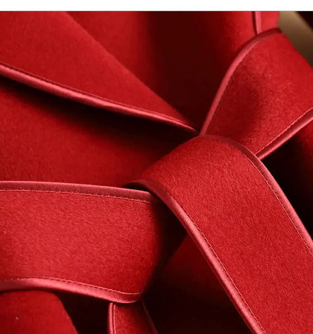 Close-up detail shot of a red woven or braided textile surface with layered loops and a black text bar at the bottom containing Chinese characters.