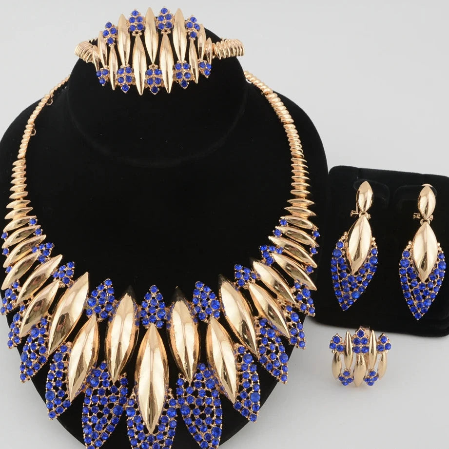 Gold and blue jewelry set including necklace, earrings, and ring on a black stand.